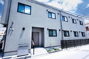 A modern hotel building with a metal facade, multiple windows, and a visible entrance. - WANOKAEDE HOTEL NEW WING (Tokyo)