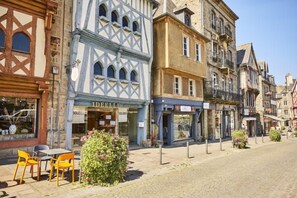 Un carrer empedrat flanquejat per edificis històrics, incloent-hi una botiga amb el rètol "DEELLE".