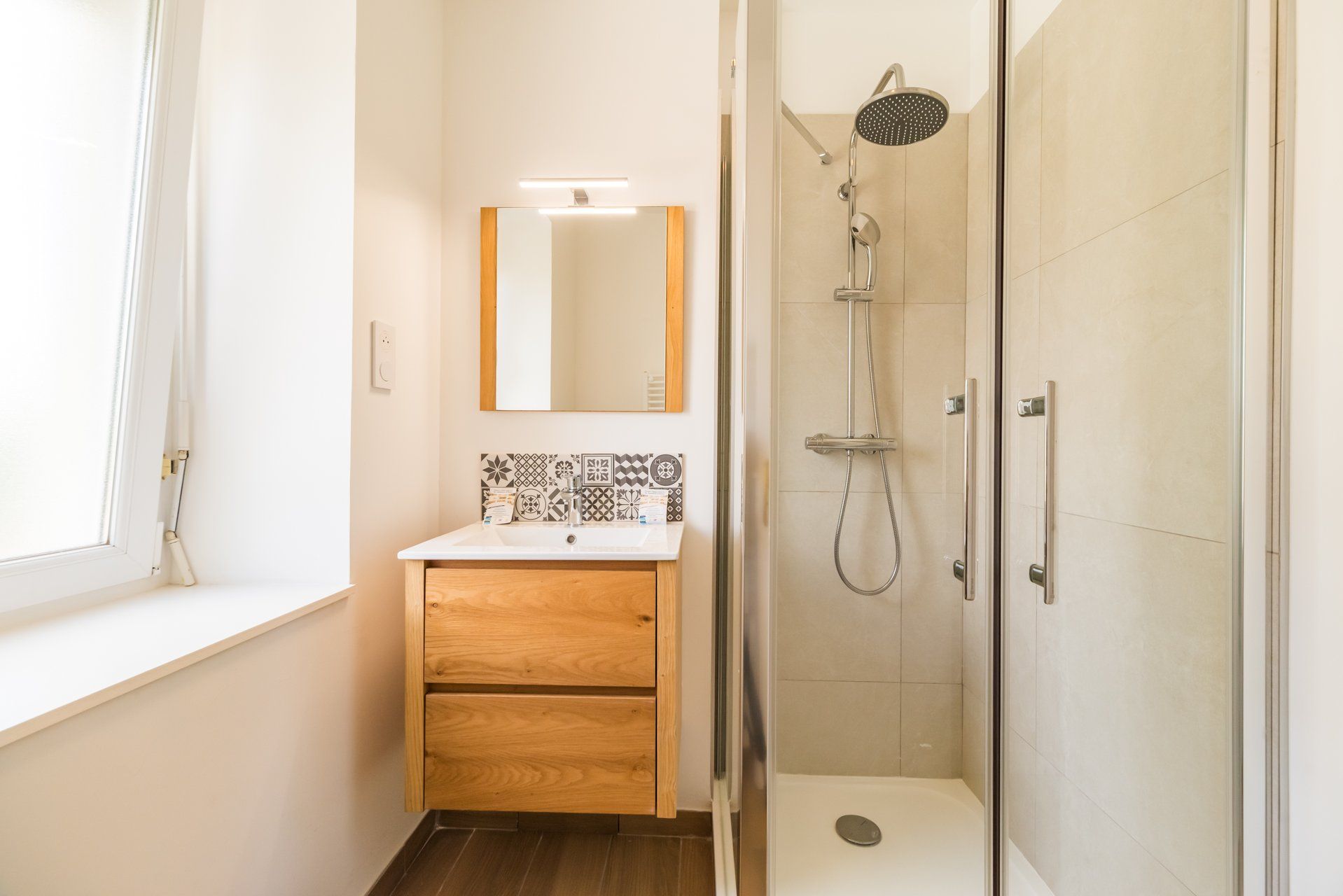 Une salle de bain avec une douche, un miroir et un lavabo.