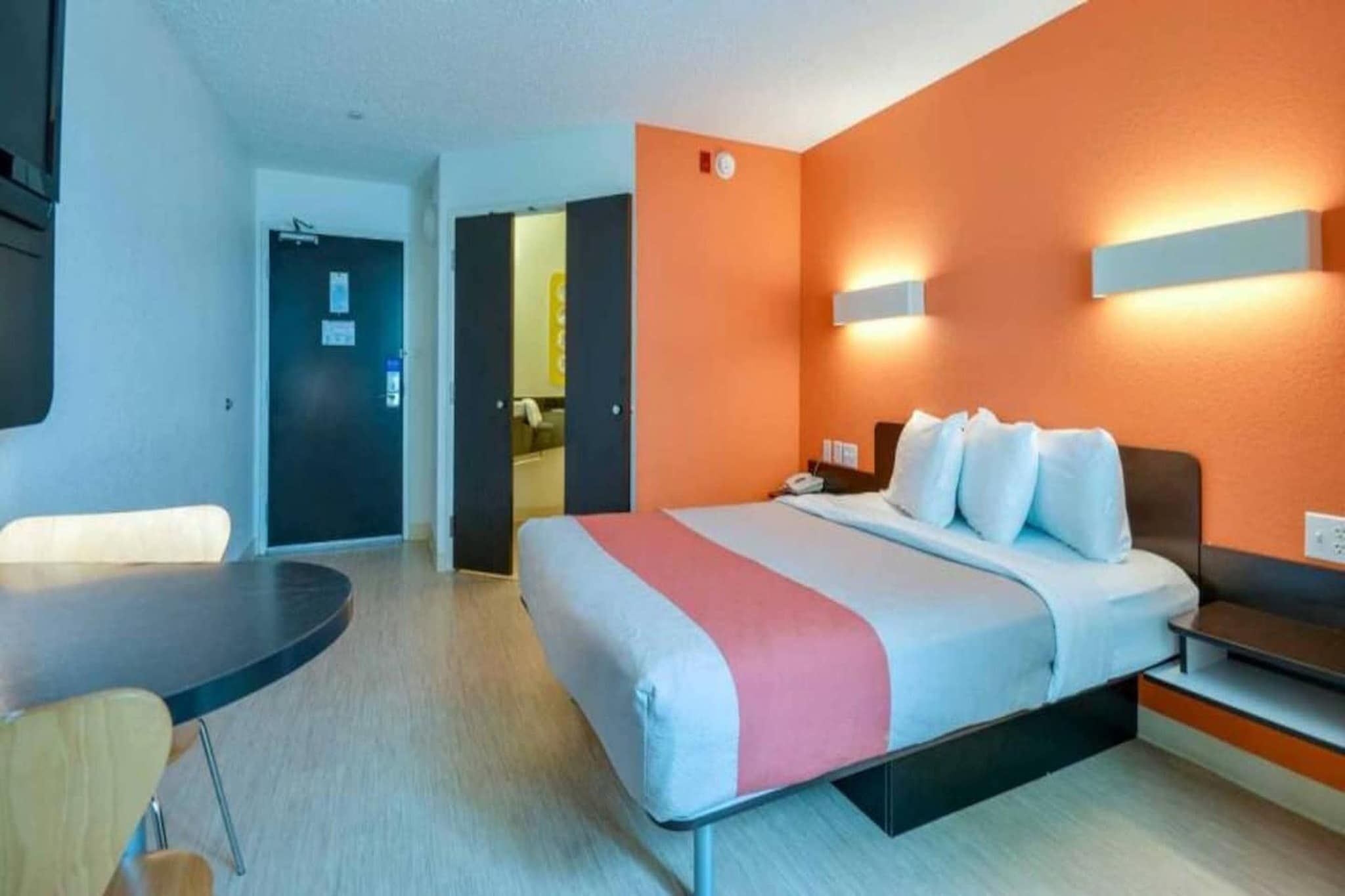 Une chambre d’hôtel avec un lit, une table de chevet et un bureau.