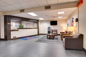 A reception area with a counter, seating, a TV, and a water dispenser.