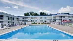 Una piscina amb una superfície d'aigua blava i cristal·lina, envoltada per una tanca blanca.