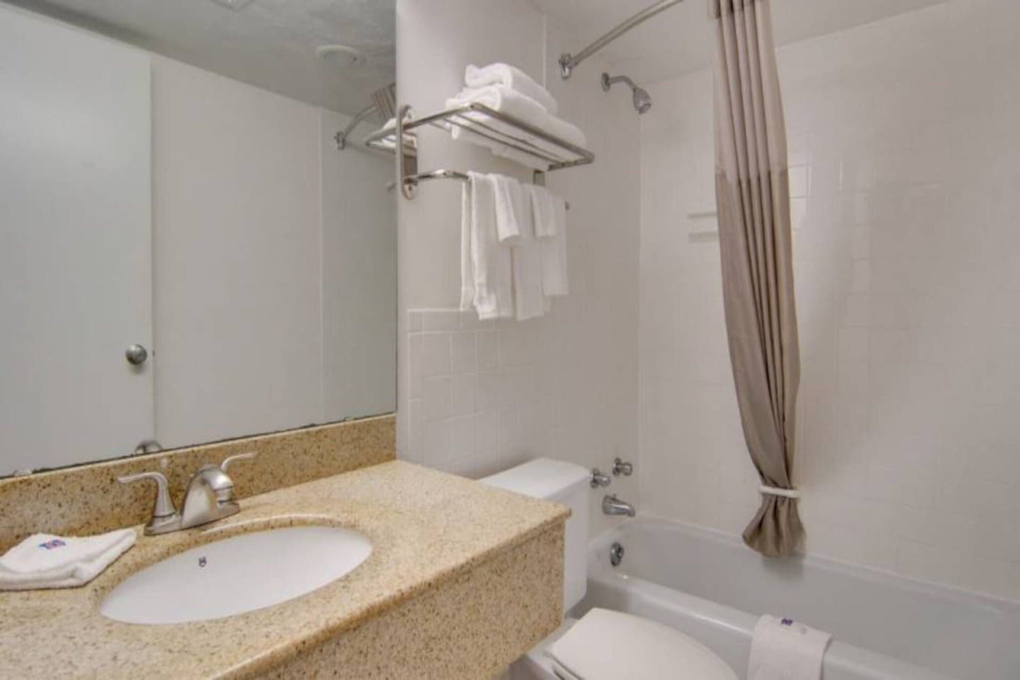 Un baño con lavamanos, inodoro y ducha.