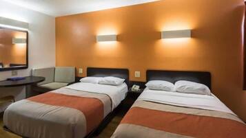 Une chambre d’hôtel avec deux lits, un bureau et une chaise.