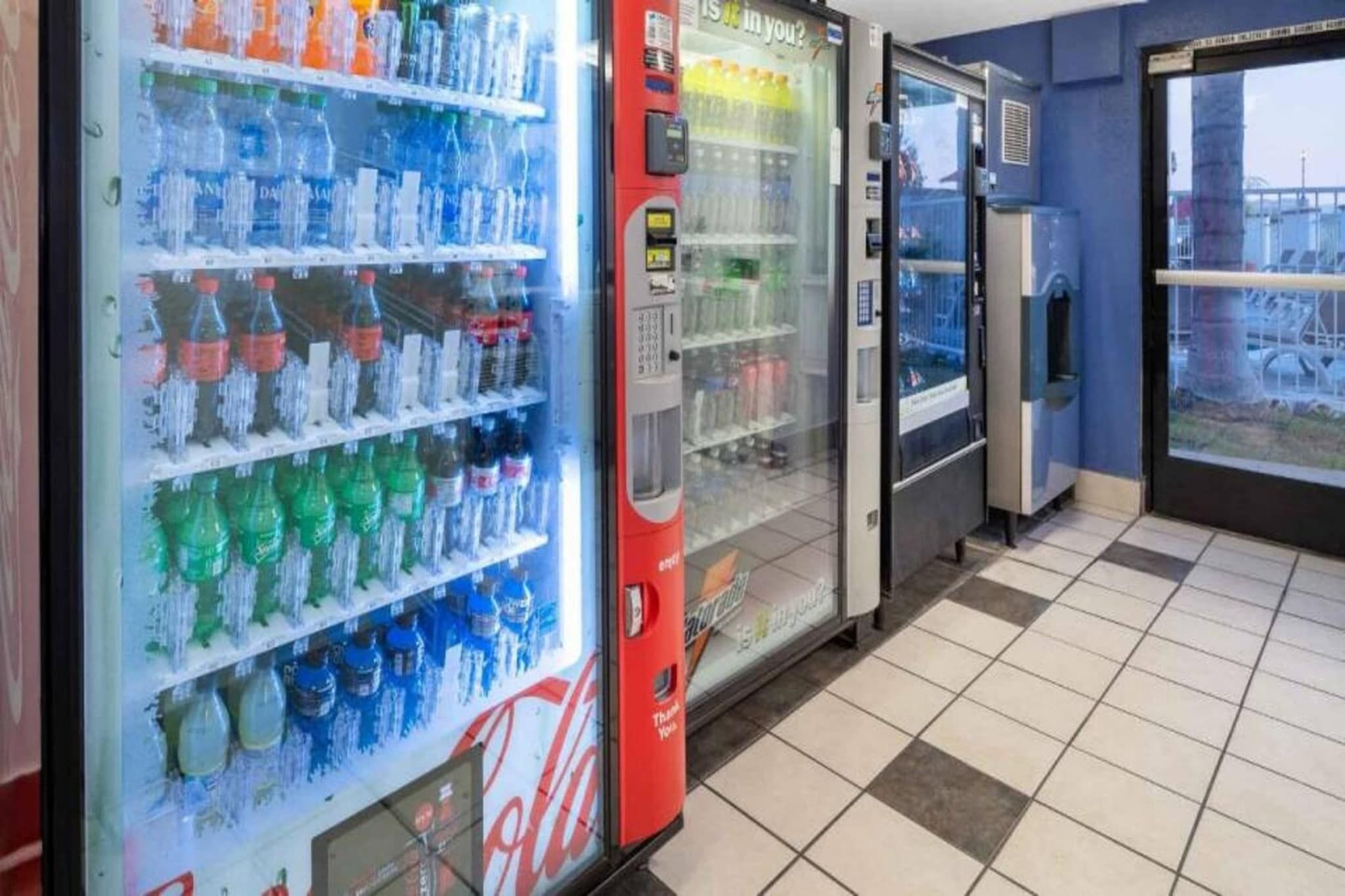 A row of beverage vending machines with various drink options.