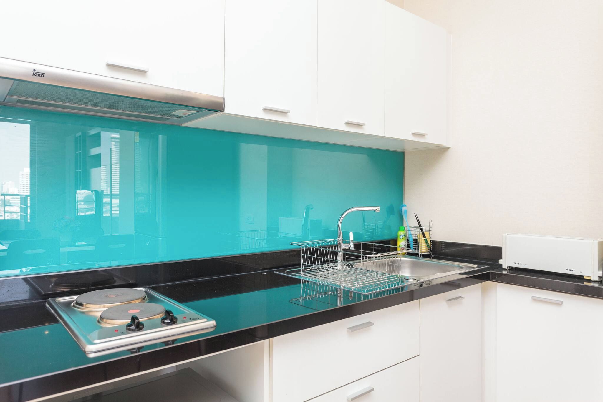 A modern kitchen with a black countertop, a sink, and a dishwasher.