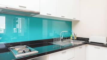 A modern kitchen with a black countertop, a sink, and a dishwasher.