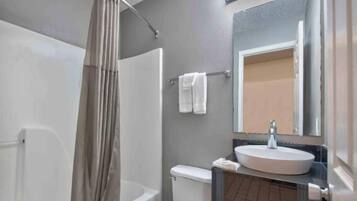 Un baño con bañera, inodoro y lavamanos.