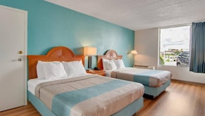 Een hotelkamer met twee bedden, een raam met uitzicht en een deur.