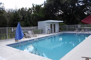 A swimming pool with a lifeguard station, lounge chairs, and a fenced area. - 2 Full Beds | Extended Suite (Kissimmee)