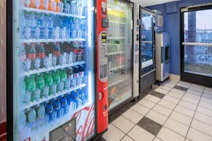 A row of beverage vending machines with various drink options.