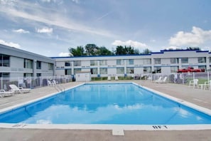 A swimming pool with a clear blue water surface, surrounded by a white fence. - 1 Queen Bed | Non-Smoking (Clarion)
