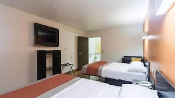 A hotel room with two beds, a television mounted on the wall, and a desk with a chair.