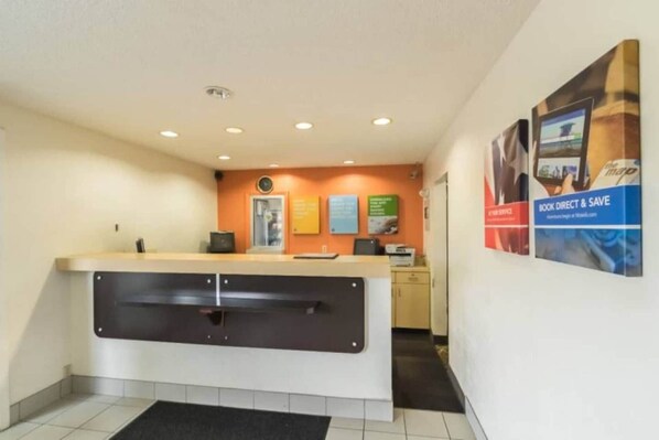 A reception area with a counter, a computer, and a wall with informational posters.
