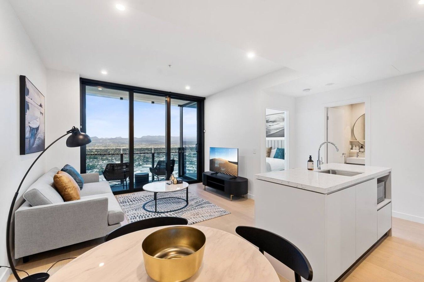 A modern apartment with a balcony, a dining area, and a kitchen.