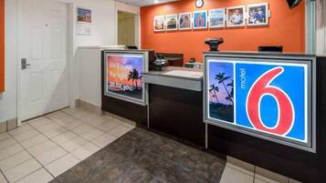 Un espace d’accueil comprenant un comptoir, une horloge et un mur orné de tableaux.
