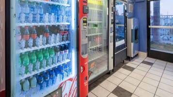 Una fila di distributori automatici di bevande con diverse opzioni.