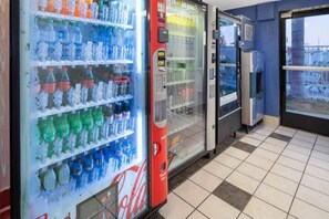 A row of beverage vending machines with various drink options.