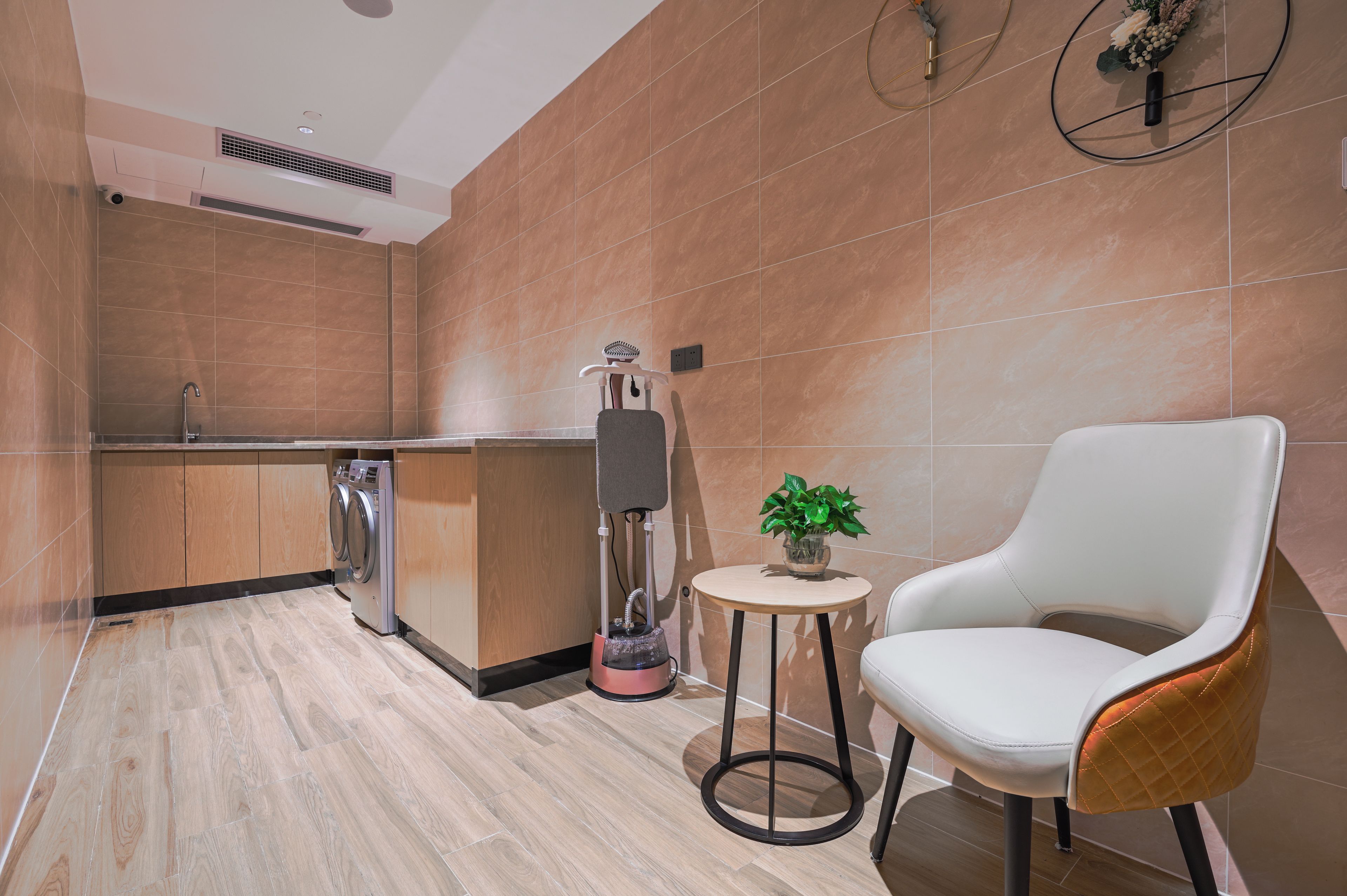 Un baño moderno con lavamanos, espejo y secador de pelo sobre un soporte.