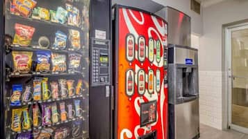 A vending machine with various snacks and a Coca-Cola branded machine.