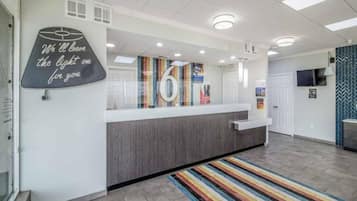 A reception area with a counter, a chalkboard with a message, and a striped rug.