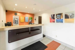 A reception area with a counter, a clock, and informational posters on the wall.