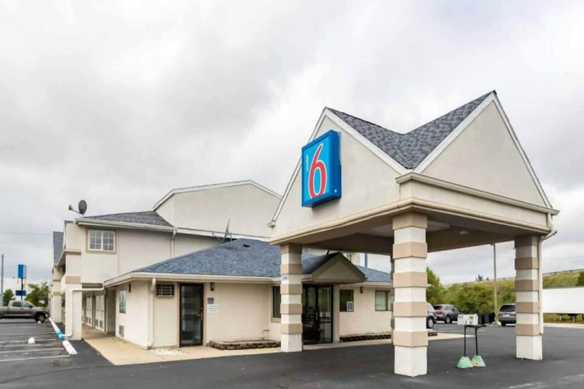 A motel with a '6' sign, a covered parking area, and a single-story building.