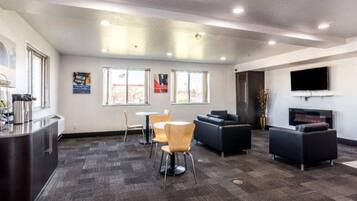 A modern lounge area with a bar, seating, and a flat-screen TV.
