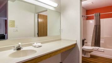 A bathroom with a sink, mirror, and toilet.