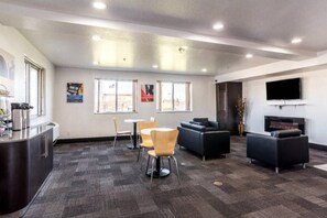 A modern lounge area with a bar, seating, and a flat-screen TV.