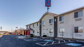 Ein Motel mit einer '6', einem Parkplatz und einem Gebäude mit vielen Fenstern.