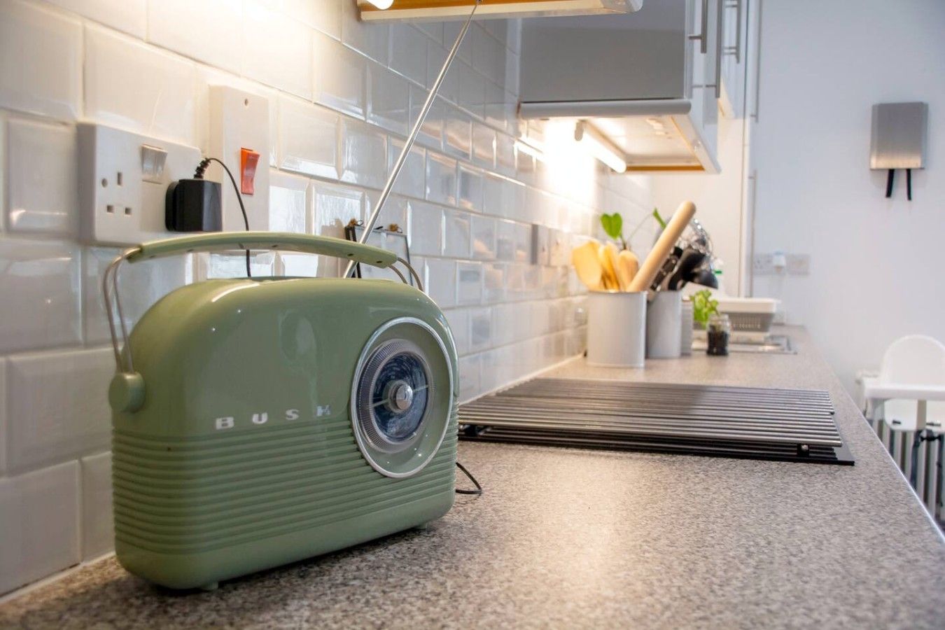 Een keuken met een vintage radio, een aanrecht en een spatwand.