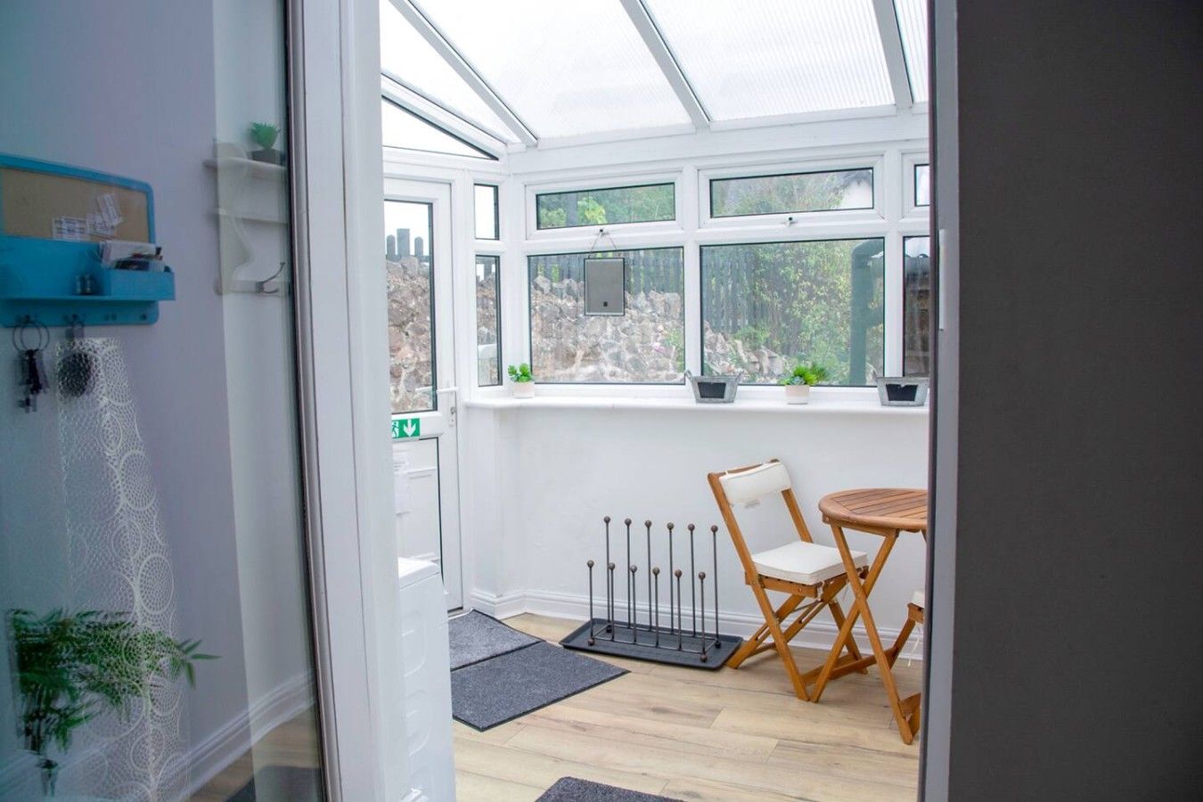 Une véranda avec une chaise et une table en bois, un radiateur et une vue sur l’extérieur.