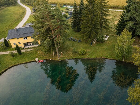 A residential area with a house, a pond, and a road. - Vrbo Property (St. Michael Bleiburg)