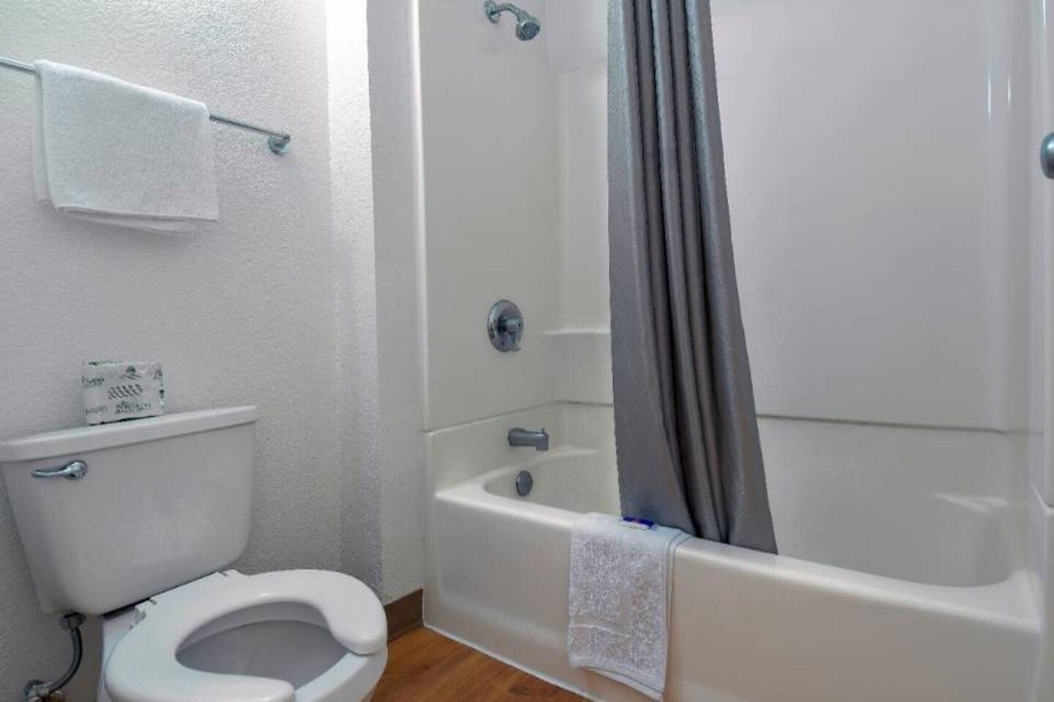 A bathroom with a toilet, a bathtub, and a shower.