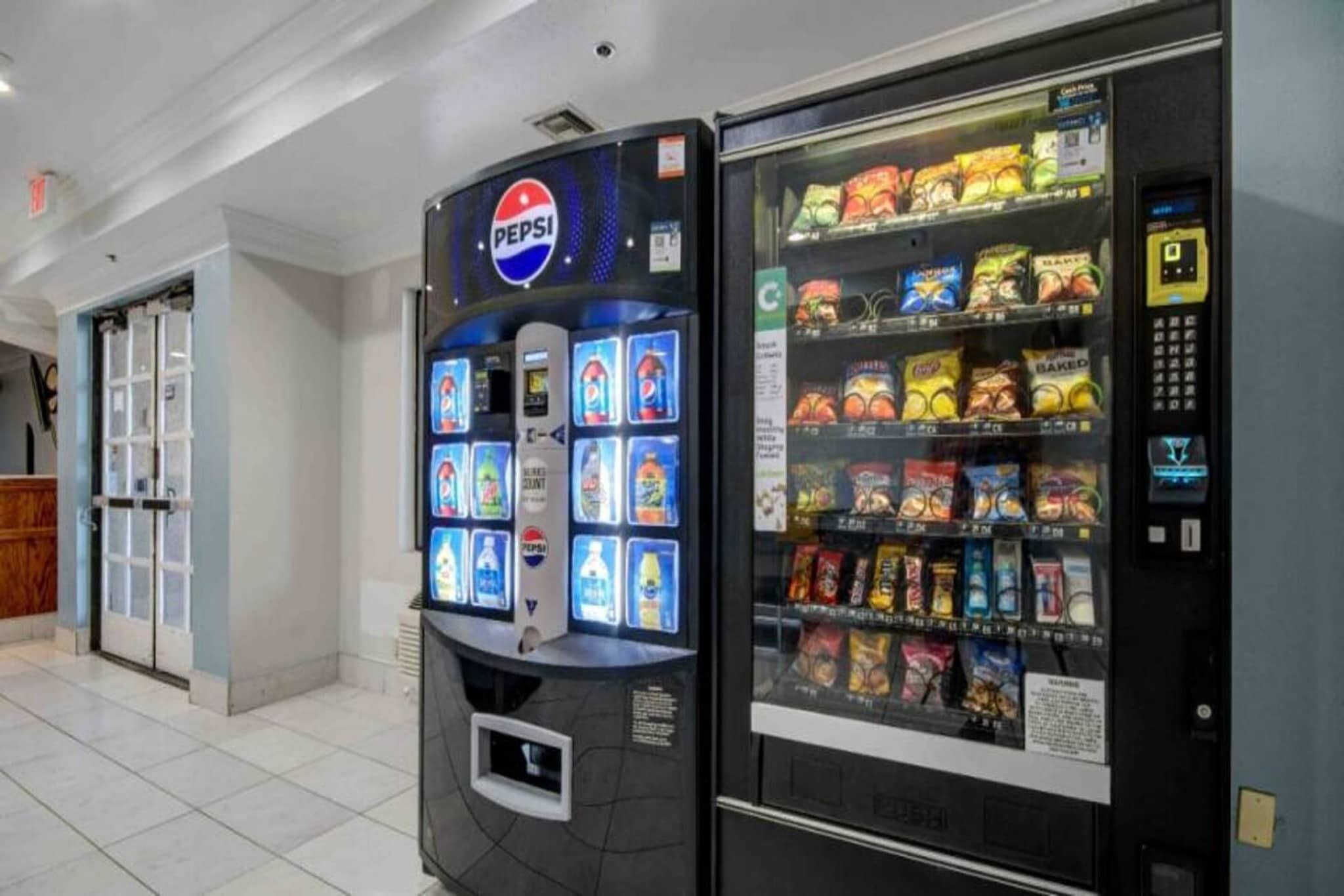 Máquina de vendas com logotipo da Pepsi e máquina de lanches com diversos produtos.