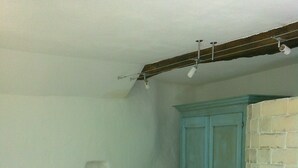 Un dormitorio con cama, mesita de noche, lámpara y armario.