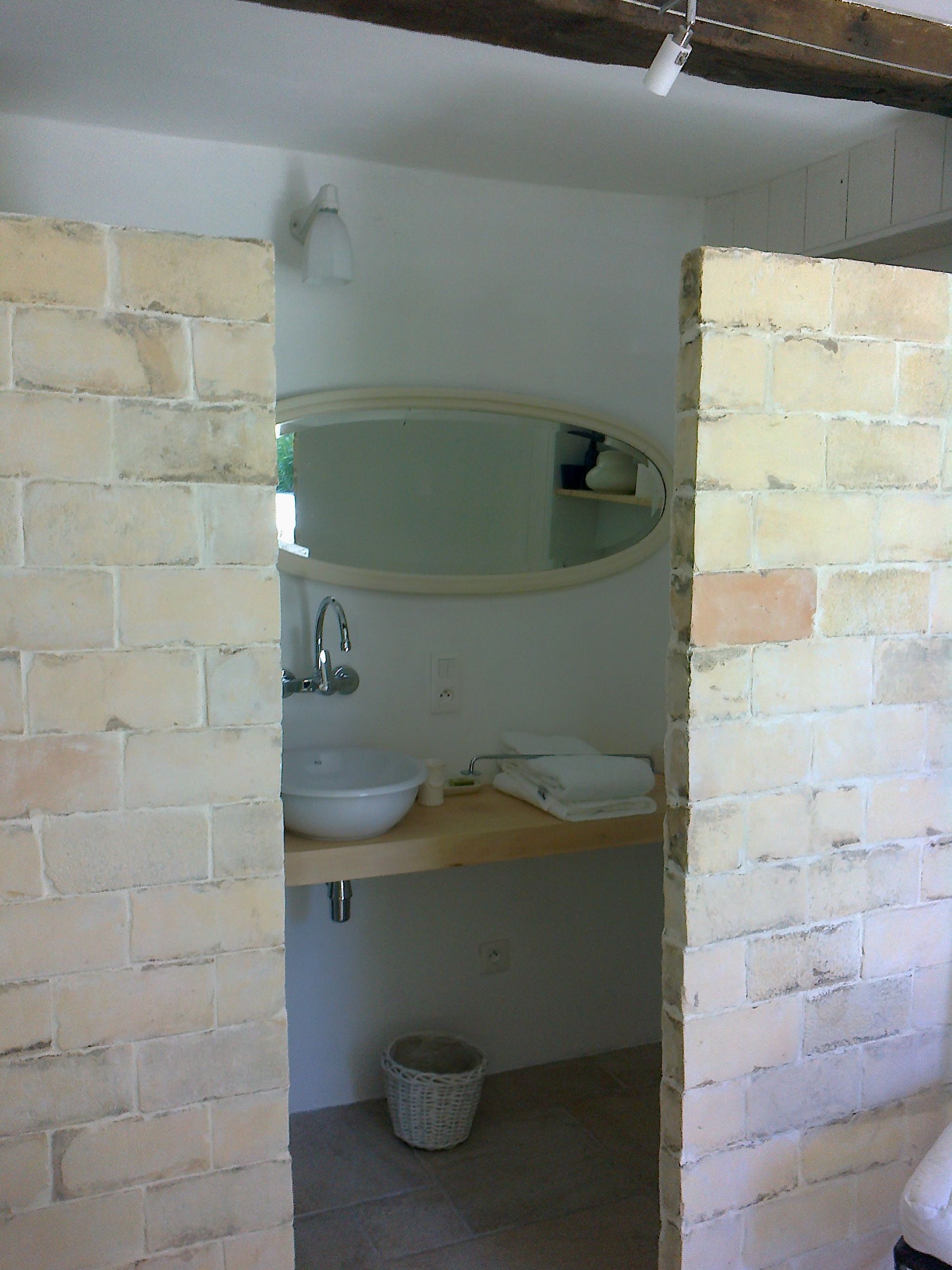A bathroom with a white sink, a mirror, and a towel rack.