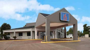 Un motel doté d’un grand parking et d’une entrée abritée.