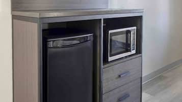 A kitchen area with a microwave and a refrigerator.