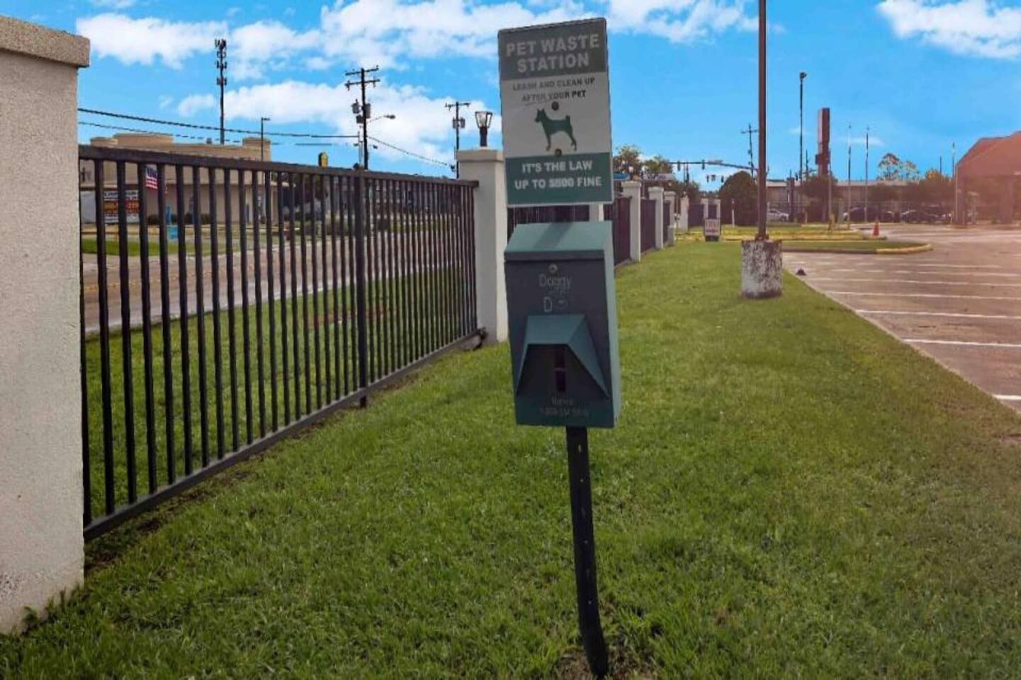 A pet waste station with a sign indicating a fine for non-compliance.