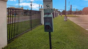 A pet waste station with a sign indicating a fine for non-compliance.