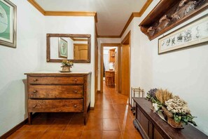 A hallway with a wooden dresser, a mirror, and a wall-mounted picture frame. - Spacious Apartment for 6 with Tofane Views and Panoramic Terrace (Cortina d'Ampezzo)