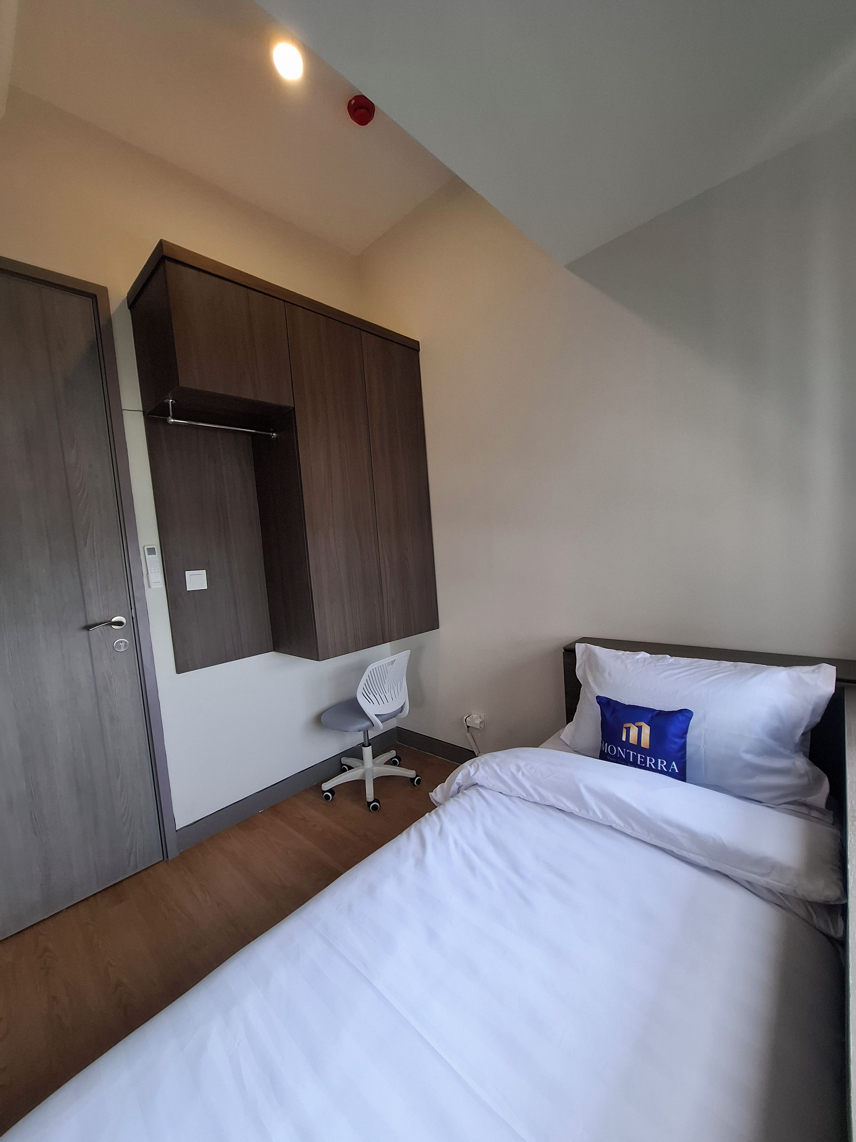Una habitación de hotel con cama, escritorio, silla y armario.