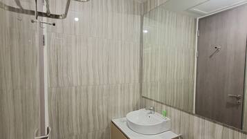 Un baño moderno con ducha, inodoro y lavabo.