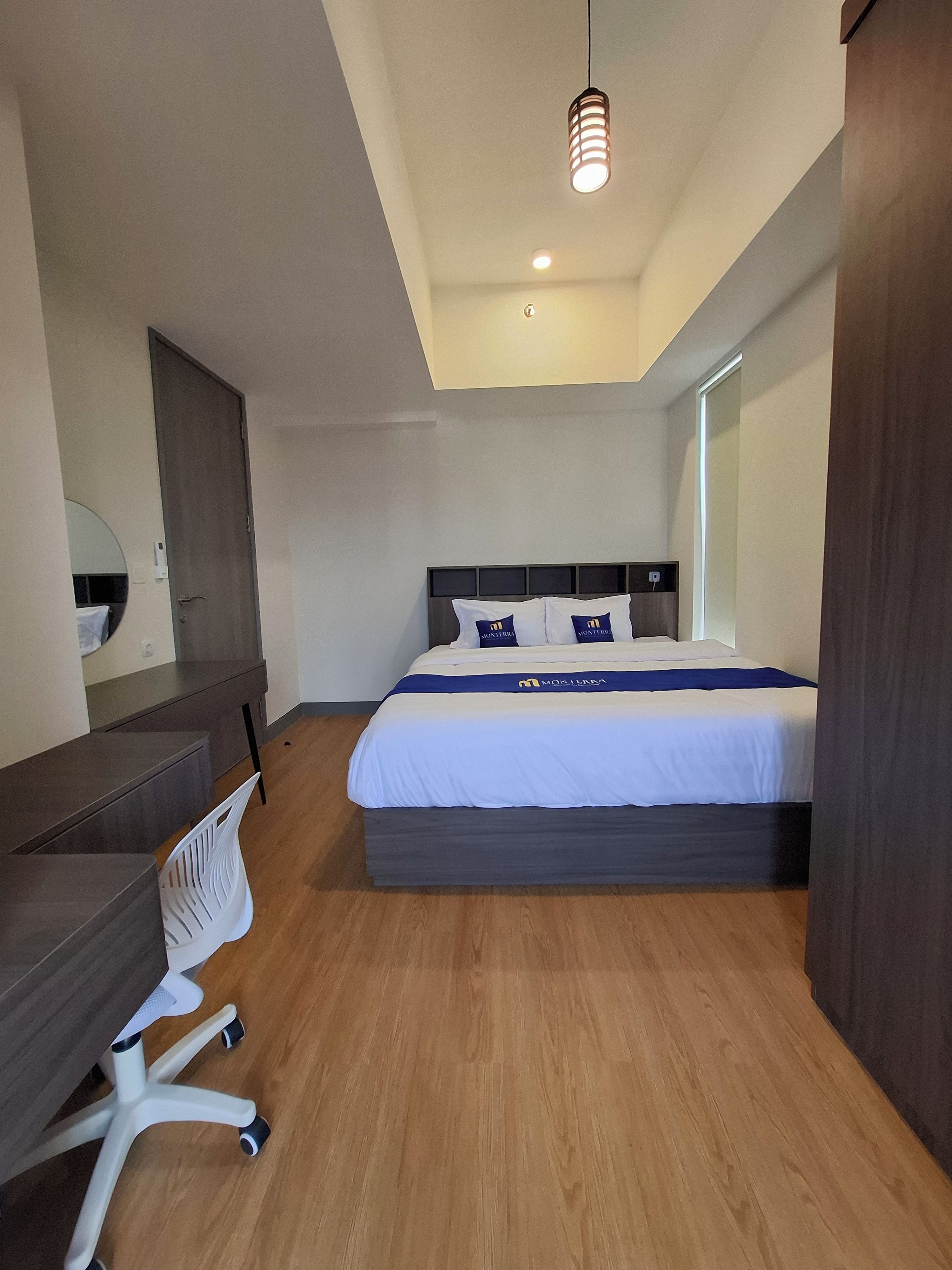 Habitació d'hotel moderna amb un llit gran, un escriptori i una cadira.
