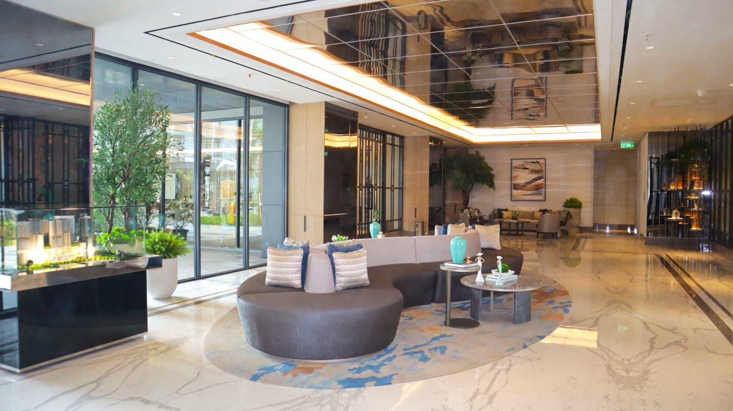 A modern lobby with a reception desk, seating area, and a large window.