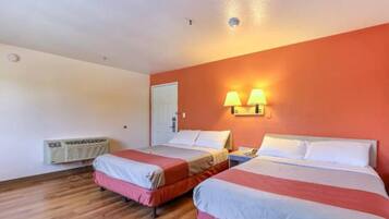 A hotel room with two beds, a heater, and two wall-mounted lamps.