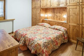 Una camera da letto con un letto di legno, un comodino e una lampada.