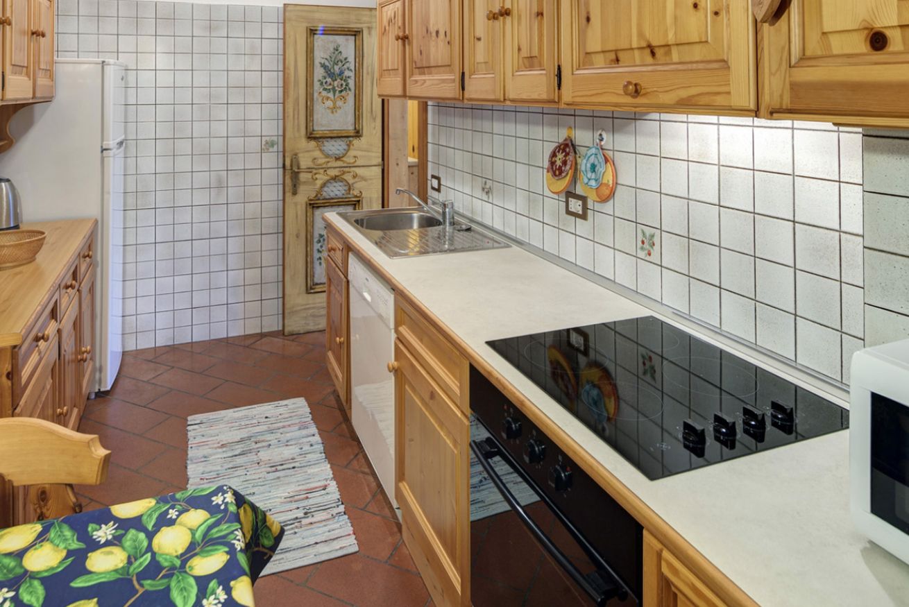 Una cucina con mobili in legno, un frigorifero bianco, un piano cottura e un lavandino.